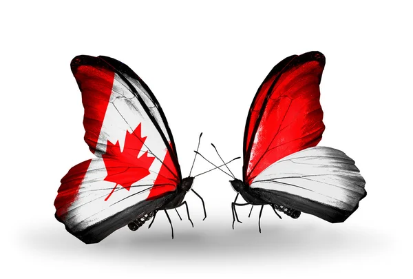 Due farfalle con bandiere sulle ali come simbolo delle relazioni Canada e Monaco, Indonesia — Foto Stock