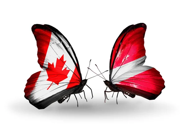 Due farfalle con bandiere sulle ali come simbolo delle relazioni Canada e Lettonia — Foto Stock