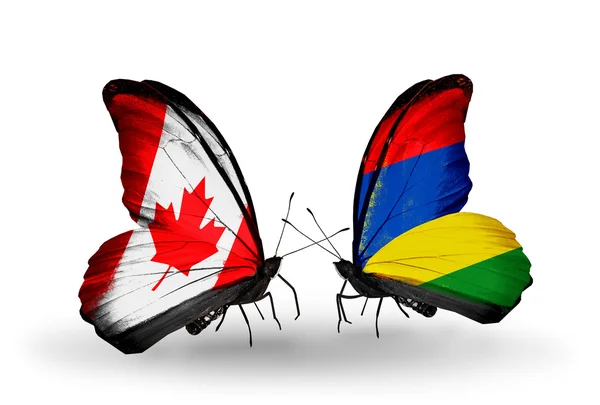 Dva motýli s vlajkami na křídlech jako symbol vztahů Kanady a Mauricia — Stock fotografie