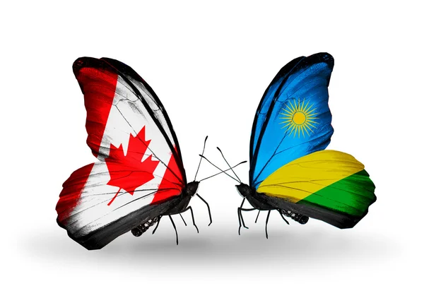 Två fjärilar med flaggor på vingarna som symbol för förbindelserna mellan Kanada och rwanda — Stockfoto