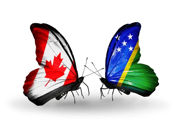 Zwei Schmetterlinge mit Flaggen auf Flügeln als Symbol der Beziehungen zwischen Kanada und den Salomonen — Stockfoto