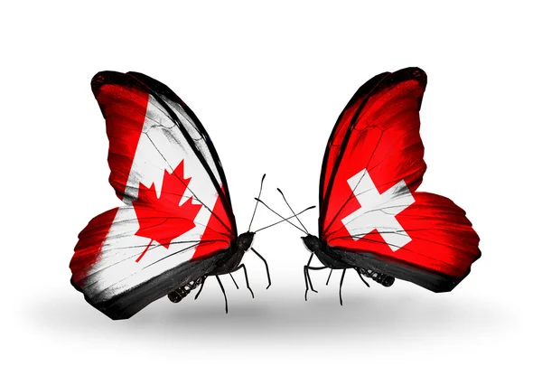 Due farfalle con bandiere sulle ali come simbolo delle relazioni Canada e Svizzera — Foto Stock