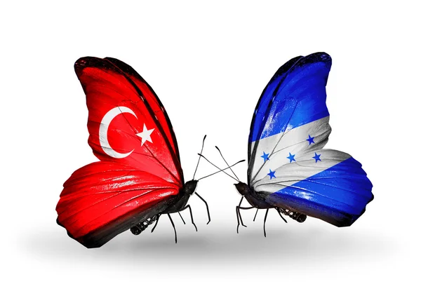 Deux papillons avec des drapeaux sur les ailes comme symbole des relations Turquie et Honduras — Photo