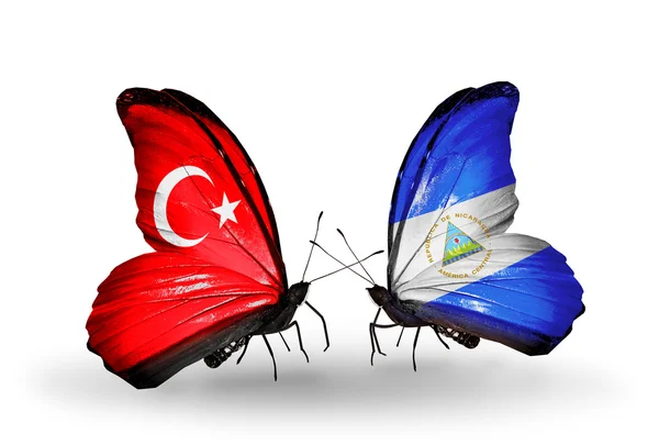 Two butterflies with flags on wings as symbol of relations Turkey and Nicaragua — Stock Photo, Image