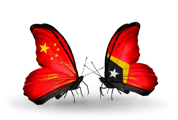 Deux papillons avec des drapeaux sur les ailes comme symbole des relations Chine et Timor oriental — Photo