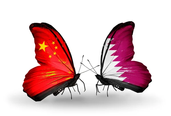 Dwa motyle z flagami na skrzydłach jako symbol stosunki Chiny i Katar — Zdjęcie stockowe