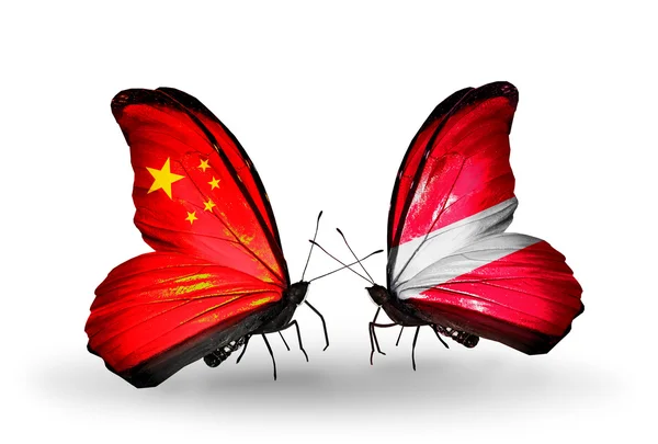 Deux papillons avec des drapeaux sur les ailes comme symbole des relations Chine et Lettonie — Photo