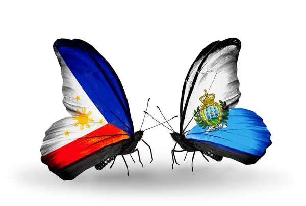 Twee vlinders met vlaggen op vleugels als symbool van de betrekkingen, Filippijnen en san marino — Stockfoto