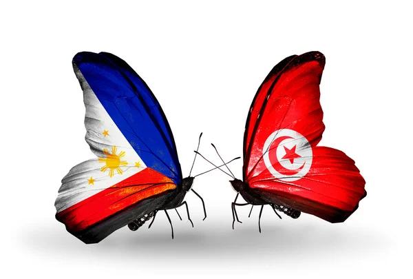 Två fjärilar med flaggor på vingarna som symbol för förbindelserna mellan Filippinerna och Tunisien — Stockfoto