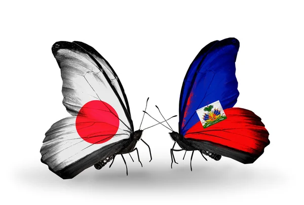 Duas borboletas com bandeiras nas asas como símbolo das relações Japão e Haiti — Fotografia de Stock