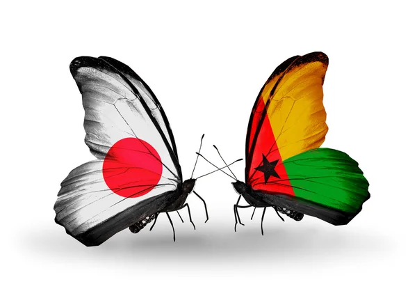 Twee vlinders met vlaggen op vleugels als symbool van betrekkingen japan en Guinee-bissau — Stockfoto