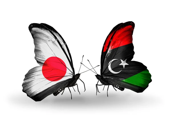 Två fjärilar med flaggor på vingarna som symbol för förbindelserna mellan japan och Libyen — Stockfoto
