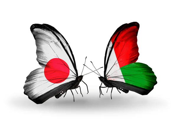 Two butterflies with flags on wings as symbol of relations Japan and Madagascar — Stock Photo, Image