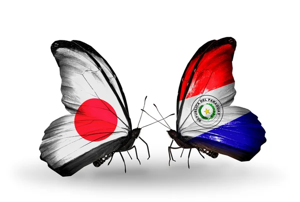 Dva motýli s příznaky na křídlech jako symbol vztahy Japonska a paraguay — Stock fotografie