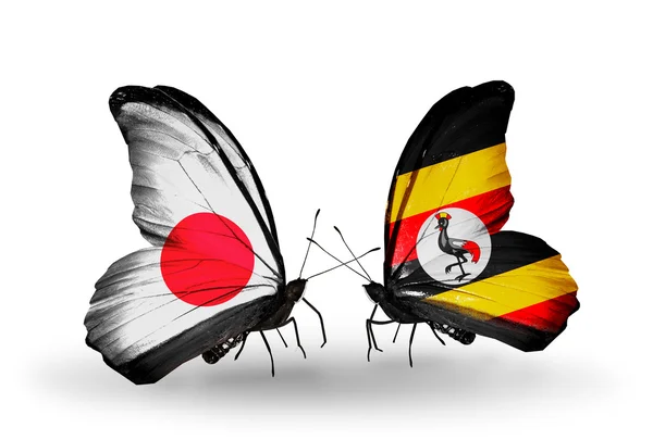 Twee vlinders met vlaggen op vleugels als symbool van betrekkingen japan en Oeganda — Stockfoto