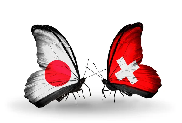 Zwei Schmetterlinge mit Flaggen auf Flügeln als Symbol der Beziehungen zwischen Japan und der Schweiz — Stockfoto