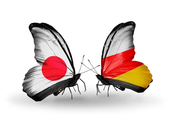 Duas borboletas com bandeiras em asas como símbolo de relações Japão e Ossétia do Sul — Fotografia de Stock