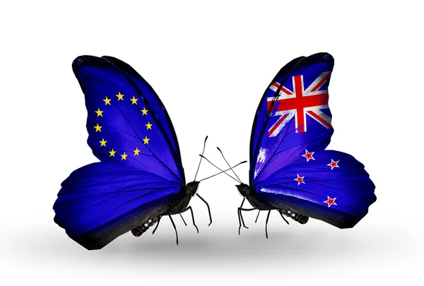 関係 eu とニュージーランドのシンボルとして翼上のフラグを持つ 2 つの蝶 — ストック写真
