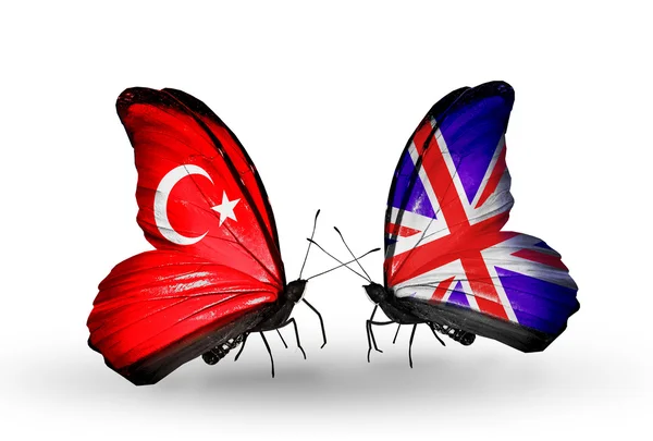 Zwei Schmetterlinge mit Flaggen auf Flügeln als Symbol der Beziehungen zwischen der Türkei und Großbritannien — Stockfoto