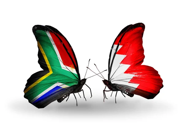Due farfalle con bandiere sulle ali come simbolo delle relazioni Sud Africa e Bahrein — Foto Stock