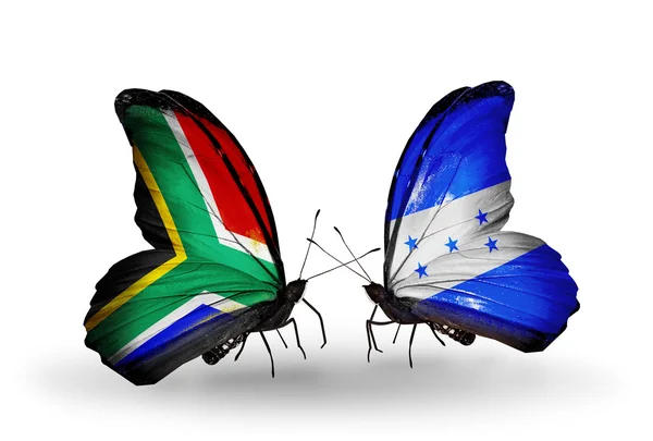 Zwei Schmetterlinge mit Flaggen auf Flügeln als Symbol der Beziehungen zwischen Südafrika und Honduras — Stockfoto