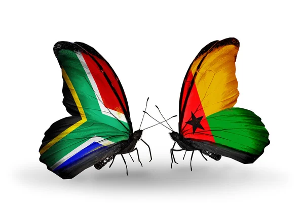 Dos mariposas con banderas en alas como símbolo de las relaciones Sudáfrica y Guinea Bissau — Foto de Stock