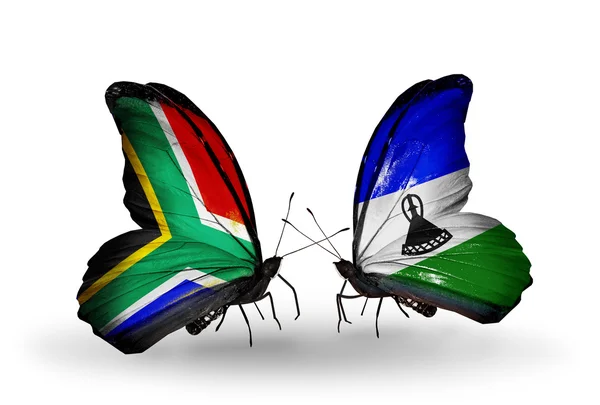 Due farfalle con bandiere sulle ali come simbolo delle relazioni Sud Africa e Lesotho — Foto Stock