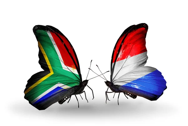 Due farfalle con bandiere sulle ali come simbolo delle relazioni Sud Africa e Lussemburgo — Foto Stock