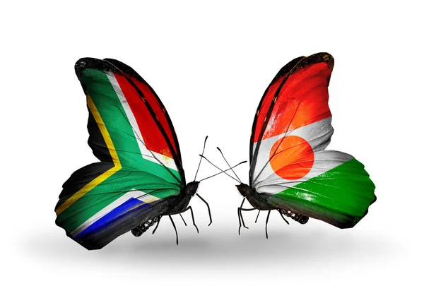 Due farfalle con bandiere sulle ali come simbolo delle relazioni Sud Africa e Niger — Foto Stock