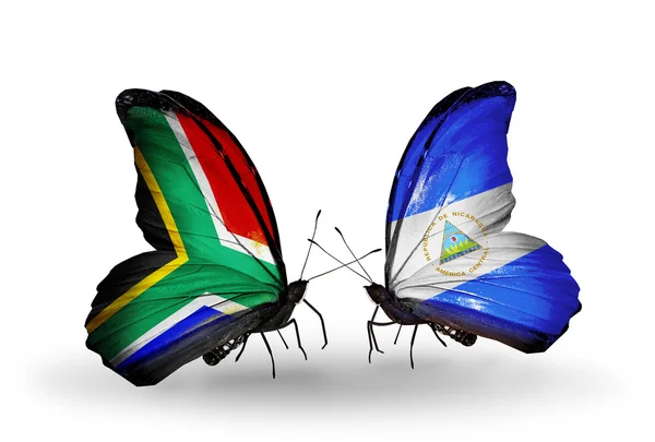 Dos mariposas con banderas en alas como símbolo de las relaciones Sudáfrica y Nicaragua — Foto de Stock