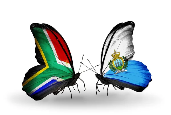 Due farfalle con bandiere sulle ali come simbolo delle relazioni Sud Africa e San Marino — Foto Stock
