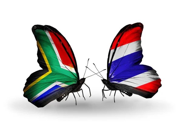 Due farfalle con bandiere sulle ali come simbolo delle relazioni Sud Africa e Thailandia — Foto Stock