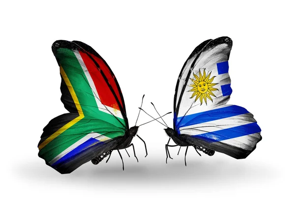 Twee vlinders met vlaggen op vleugels als symbool van de betrekkingen, Zuid-Afrika en uruguay — Stockfoto