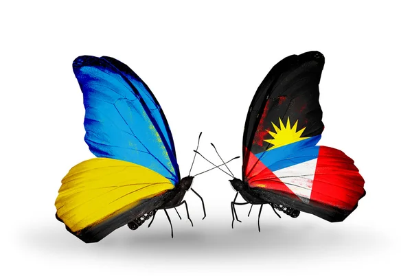 Två fjärilar med flaggor på vingarna som symbol för förbindelserna mellan Ukraina och antigua och barbuda — Stockfoto