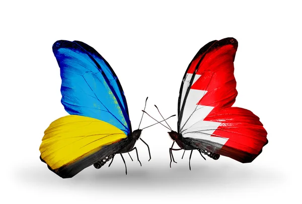 Two butterflies with flags on wings as symbol of relations Ukraine and Bahrain — Stock Photo, Image