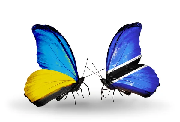 Dva motýli s příznaky na křídlech jako symbol vztahů, Ukrajině a v Botswaně — Stock fotografie