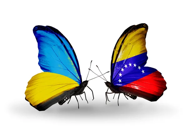 Dos mariposas con banderas en alas como símbolo de relaciones Ucrania y Venezuela —  Fotos de Stock