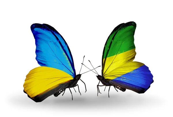 Duas borboletas com bandeiras em asas como símbolo de relações Ucrânia e Gabão — Fotografia de Stock