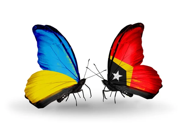 Dos mariposas con banderas en alas como símbolo de relaciones Ucrania y Timor Oriental —  Fotos de Stock