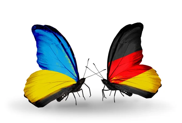 Två fjärilar med flaggor på vingarna som symbol för förbindelserna mellan Ukraina och Tyskland — Stockfoto