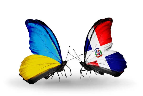 Kaksi perhosia lippuja siivet symbolina suhteiden Ukraina ja Dominicana — kuvapankkivalokuva