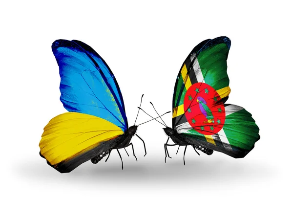Due farfalle con bandiere sulle ali come simbolo delle relazioni Ucraina e Dominica — Foto Stock