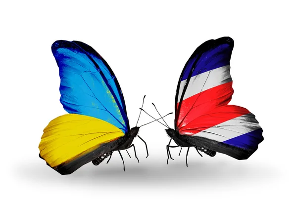 Due farfalle con bandiere sulle ali come simbolo delle relazioni Ucraina e Costa Rica — Foto Stock