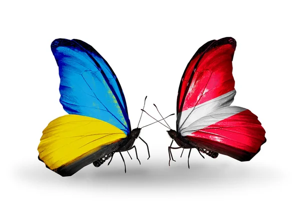 Two butterflies with flags on wings as symbol of relations Ukraine and Latvia — Stock Photo, Image