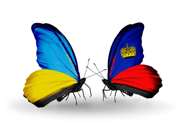 Dwa motyle z flagami na skrzydłach jako symbol stosunków Ukrainy i liechtenstein — Zdjęcie stockowe