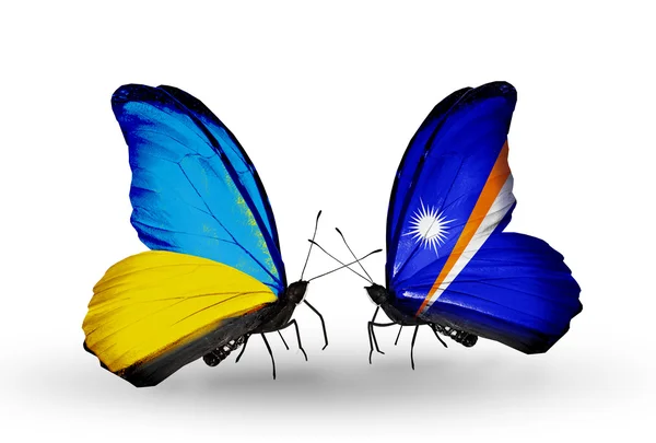 Zwei Schmetterlinge mit Flaggen auf Flügeln als Symbol der Beziehungen zwischen der Ukraine und den Marshallinseln — Stockfoto