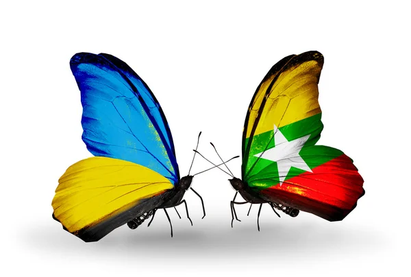 Zwei Schmetterlinge mit Fahnen auf Flügeln als Symbol der Beziehungen zwischen Ukraine und Myanmar — Stockfoto