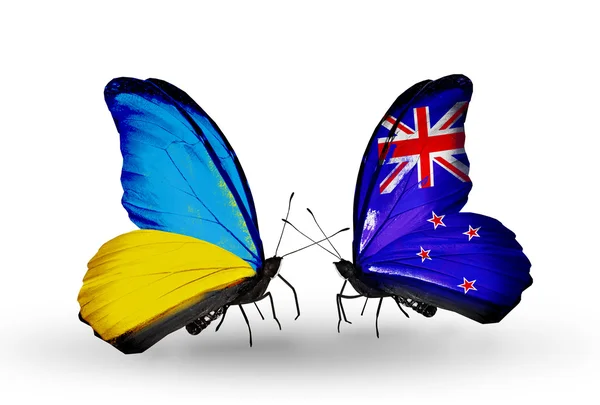Duas borboletas com bandeiras em asas como símbolo de relações Ucrânia e Nova Zelândia — Fotografia de Stock