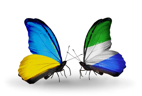 Deux papillons avec des drapeaux sur les ailes comme symbole des relations Ukraine et Sierra Leone — Photo