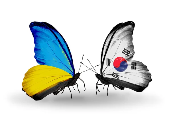 Dva motýli s příznaky na křídlech jako symbol vztahy Ukrajiny a Jižní korea — Stock fotografie